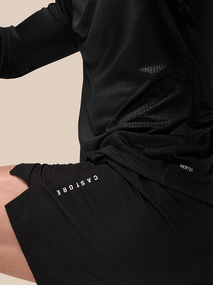 Side view of black Adapt shorts showing Aertek branding at right rear and Castore logo running vertically along left leg