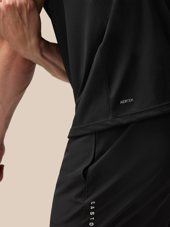 Close up of black Adapt Training T-Shirt side seam showing AERTEK branding at lower back