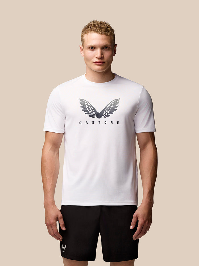 Male model wearing white Adapt Short Sleeve Graphic T Shirt with CASTORE wings logo on the chest