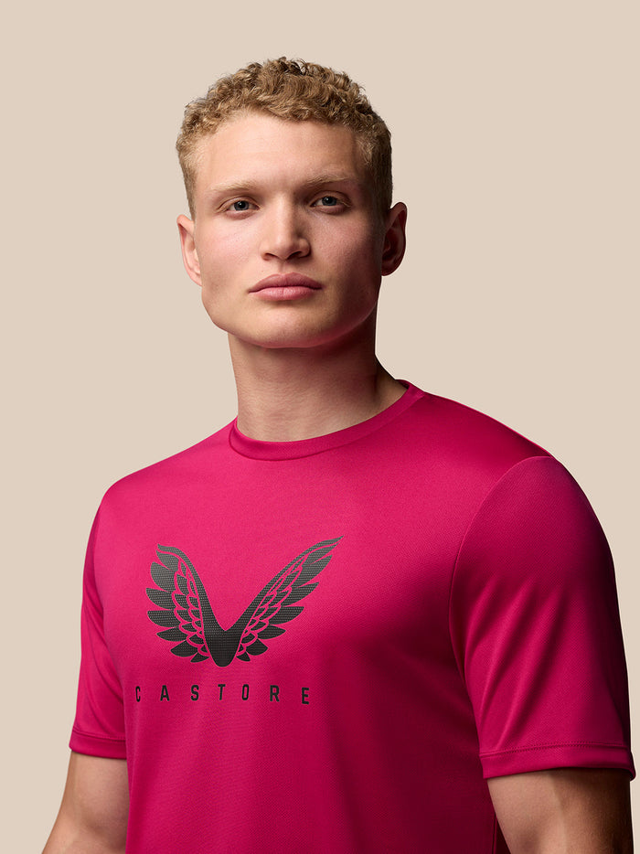 Close-up of pink Adapt Training T Shirt chest area with large black wings logo