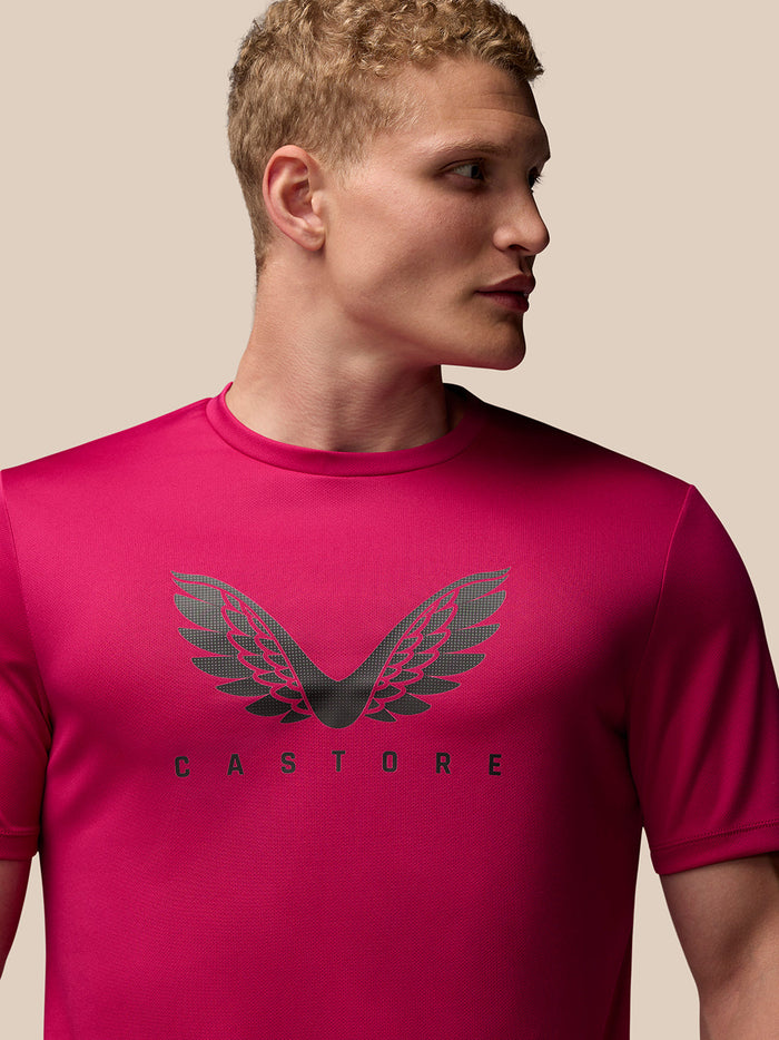 Side-angle view of a man wearing pink Adapt Training T-Shirt with Castore wings graphic on the chest