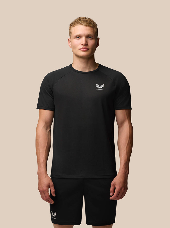 Male model wearing black Adapt Short Sleeve T-Shirt with subtle Castore branding on chest.