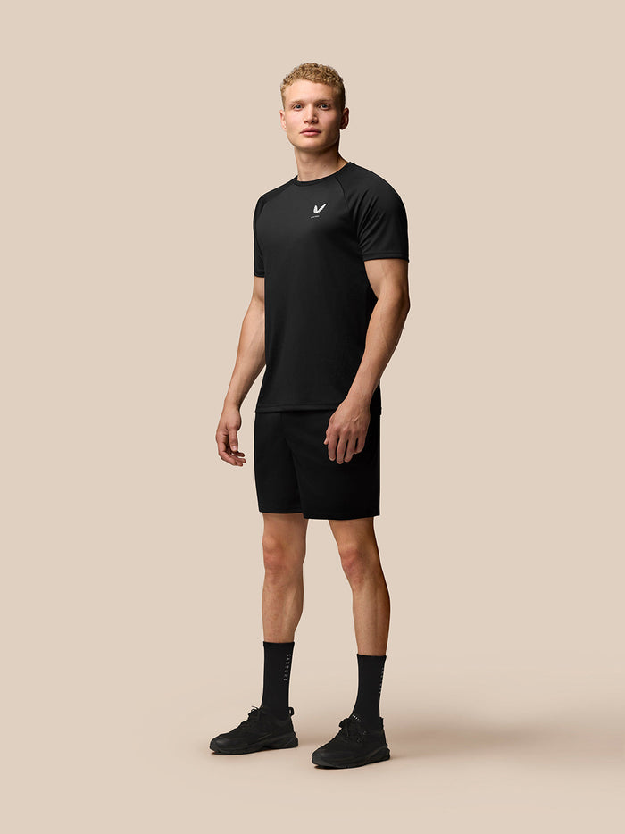 Male model wearing black Adapt Training T Shirt with raglan sleeves and Castore branding on left chest and upper back