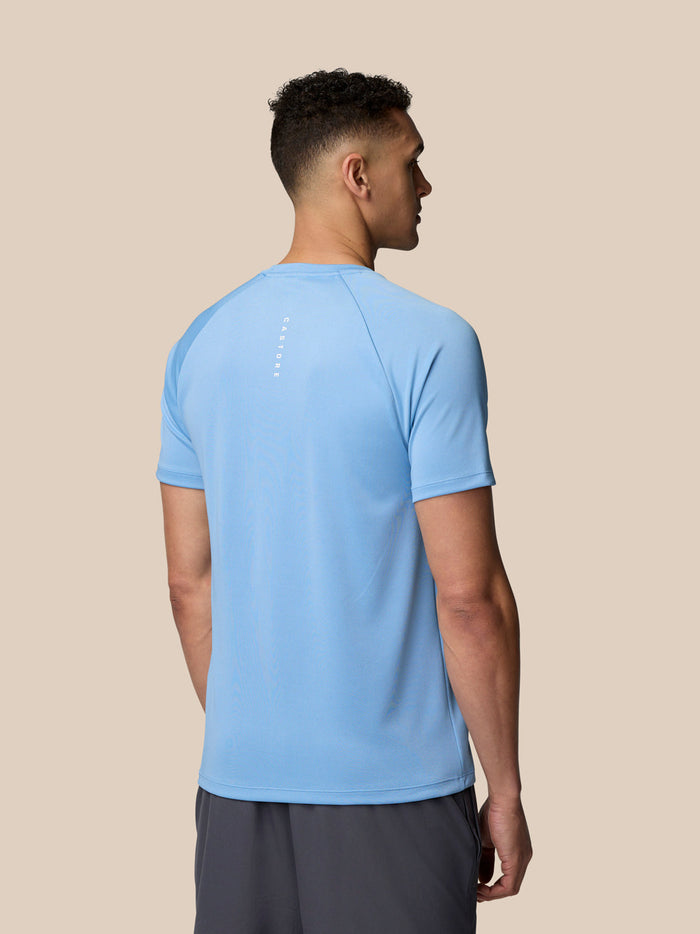 Back view of a man wearing sky blue Adapt Training T-Shirt with Castore branding on the upper back