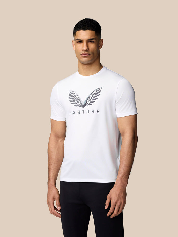 Man wearing white Graphic Training T Shirt with winged Castore logo on chest.