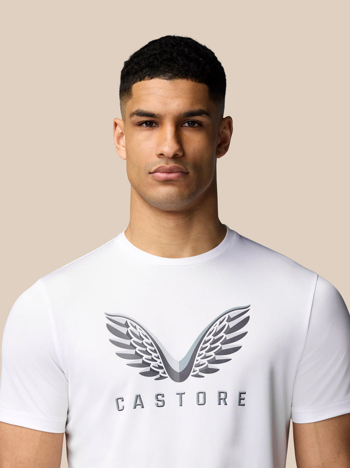 Male model wearing white graphic training T shirt with Castore wings on the chest