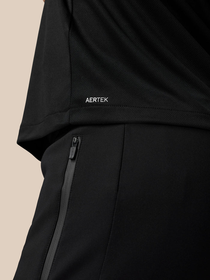 Back view of black graphic T shirt with Aertek branding at the lower back and a zip on the pants.