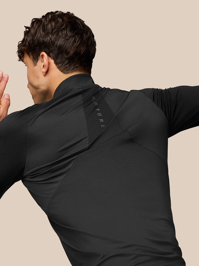 Back view of a man in the black Apex Training Quarter Zip Top showing Aeromesh branding at the left back