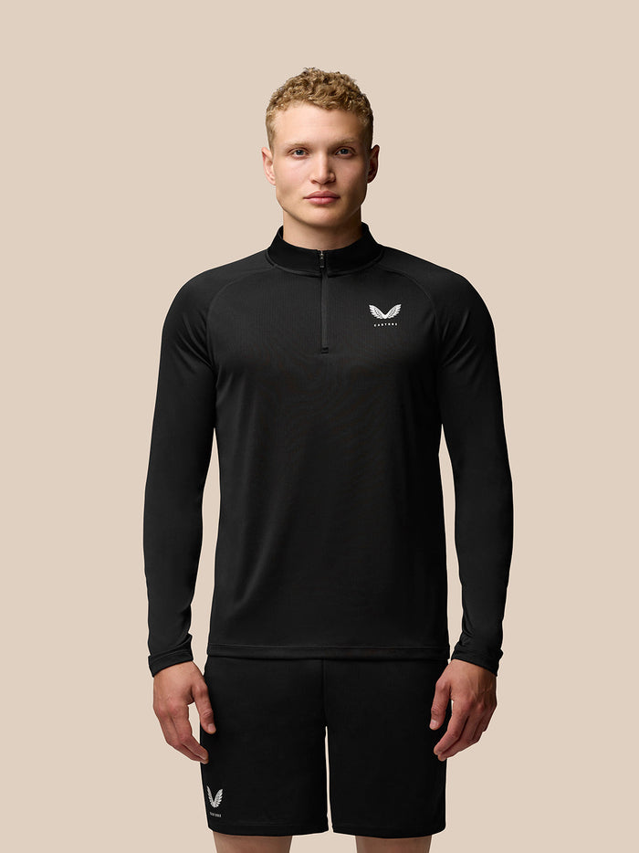 Male model wearing black Adapt Training Quarter Zip Top with stand collar and front zip, Castore branding on left chest and upper back