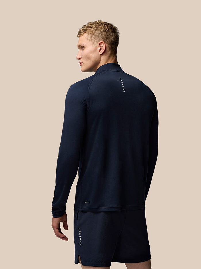 Model wearing midnight navy Adapt Training Quarter Zip Top with Castore branding on left chest and upper back