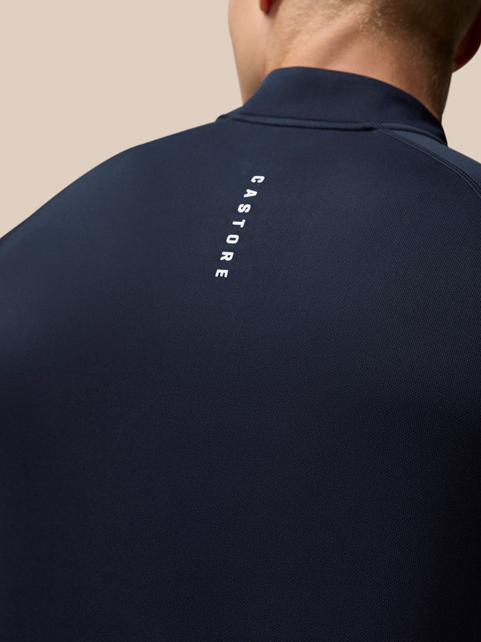 Back view of midnight navy Adapt Training Quarter Zip Top showing Castore branding on the upper back and Aertek branding on the lower back