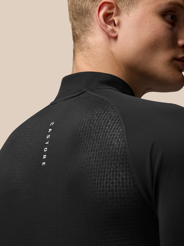 Back view of black Adapt Print Quarter Zip Top with a geometric pattern, Castore branding along the left back and Aertek branding at the lower back.