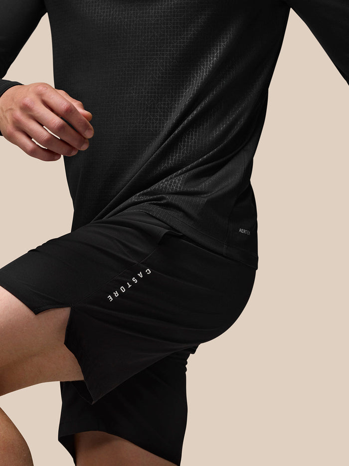 Profile view of a male model wearing black Adapt Print Quarter Zip Top, showing allover geometric pattern and Aertek branding at the lower back.