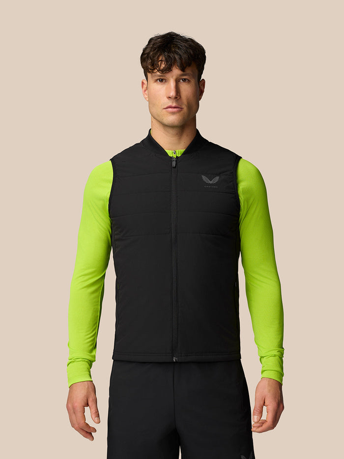 Man wearing black Protek Apex Training Gilet over neon lime long sleeves with a zipped front and chest logo
