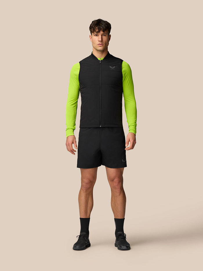 Male model wearing black Apex Training Gilet over a neon green base layer.