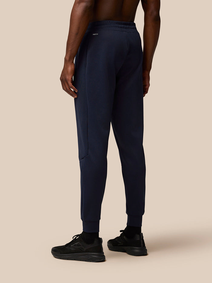 Front view of navy Flex Lifestyle Joggers on a model with elastic cuffs and drawstring waistband