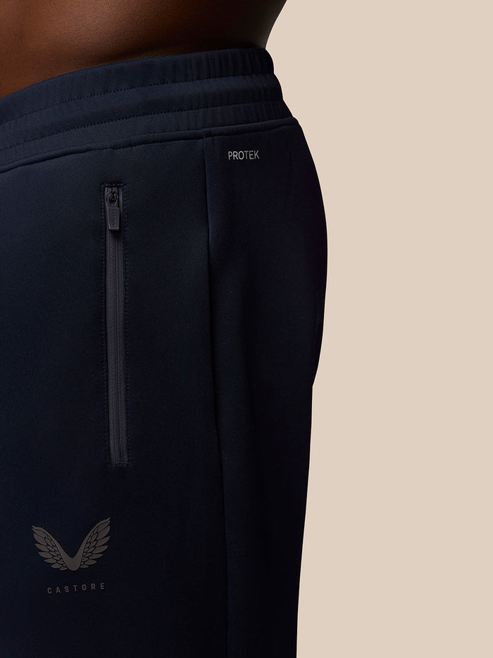 Close-up of navy Flex Lifestyle Joggers showing a vertical zip pocket and Protek branding.