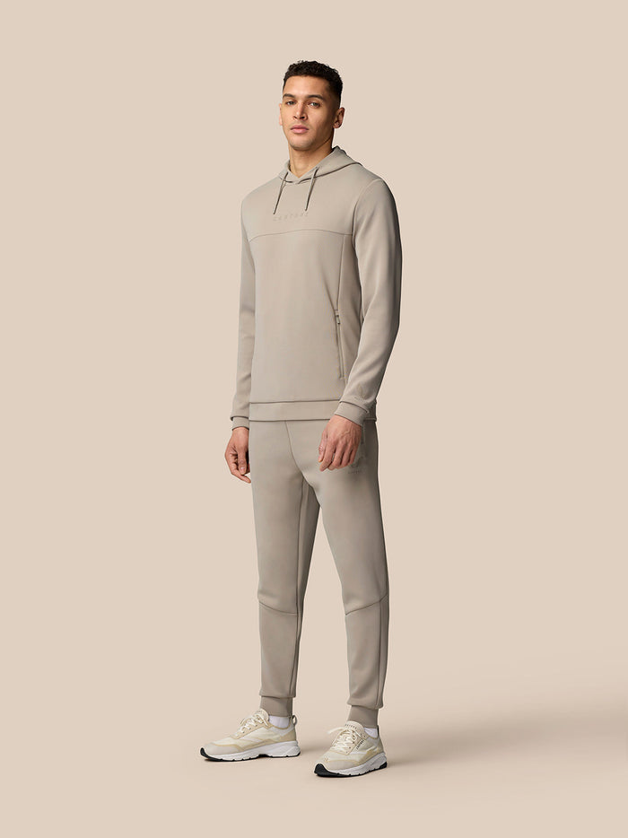 Male model wearing Rock Grey Flex Lifestyle Joggers with a matching top against a beige backdrop.