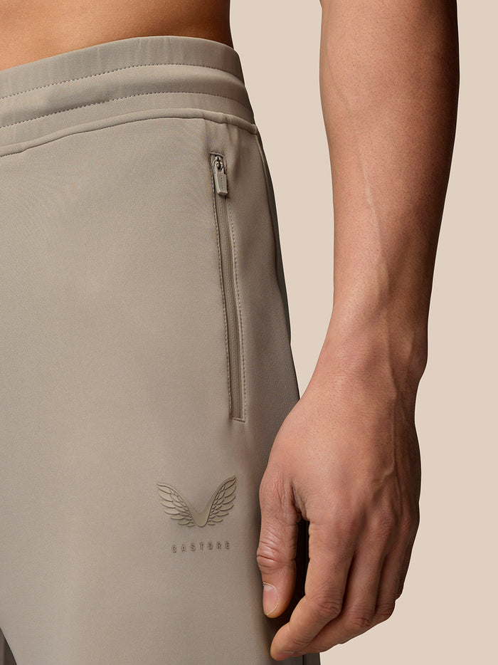 Close-up of the hip area highlighting the zip pocket and Castore logo on Rock Grey joggers.