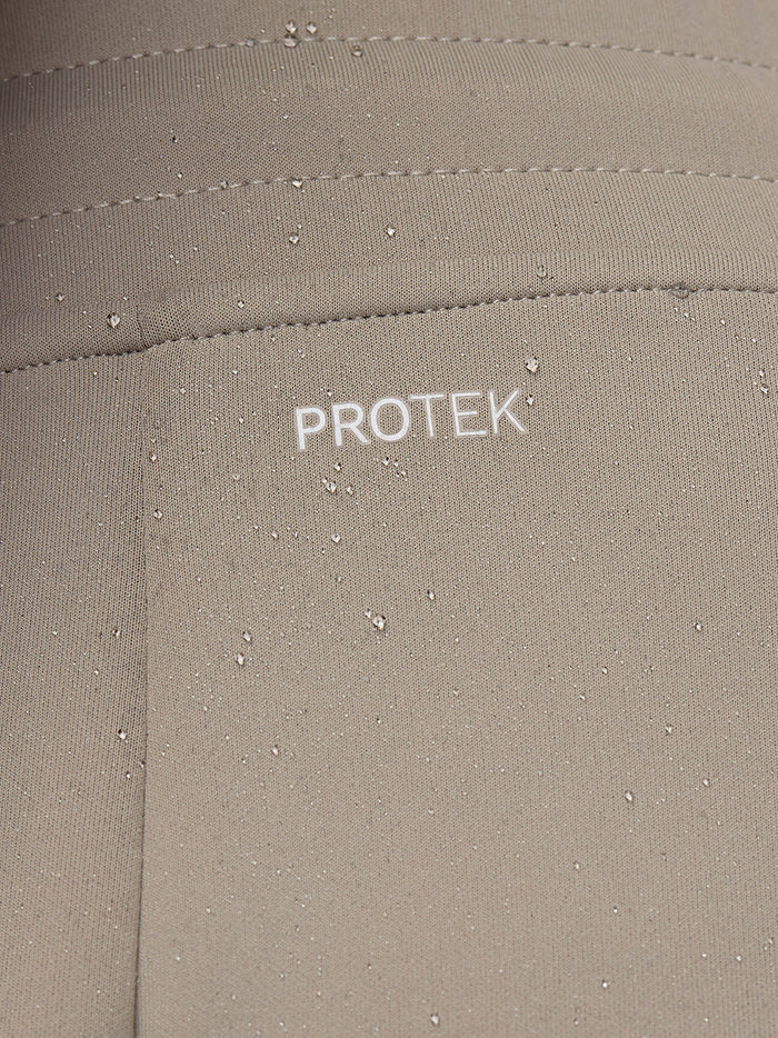 Beige Flex Lifestyle Joggers fabric close-up with PROTEK branding and water droplets.