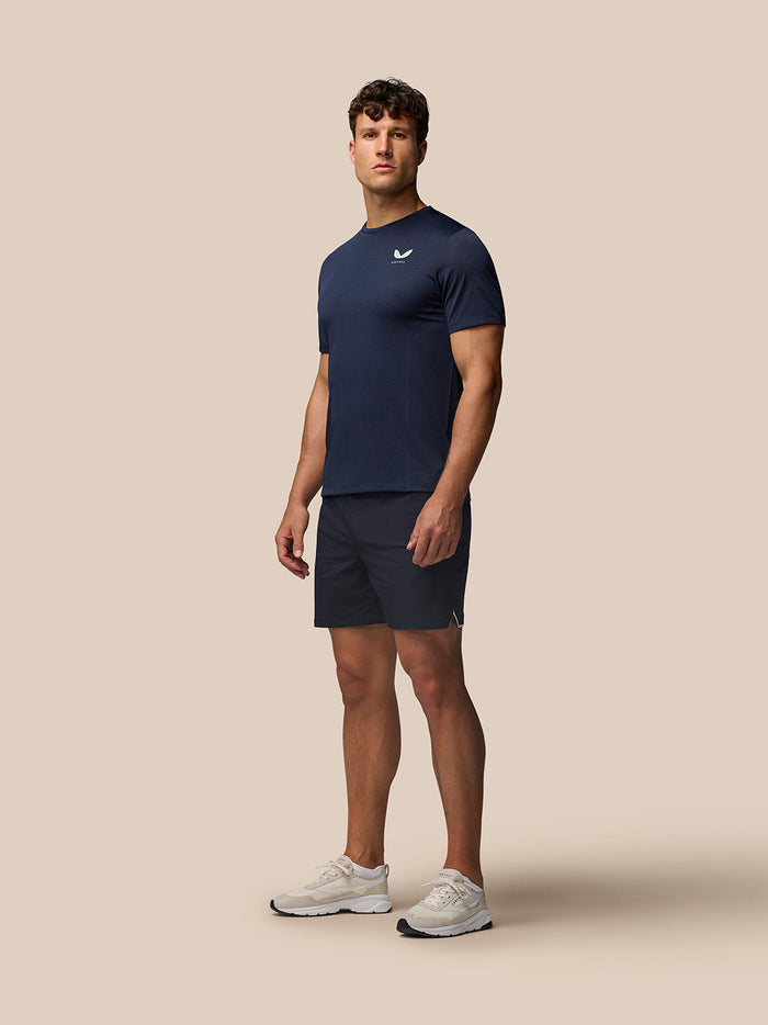 Male model wearing midnight navy Apex Training T-Shirt with crew neck and short raglan sleeves