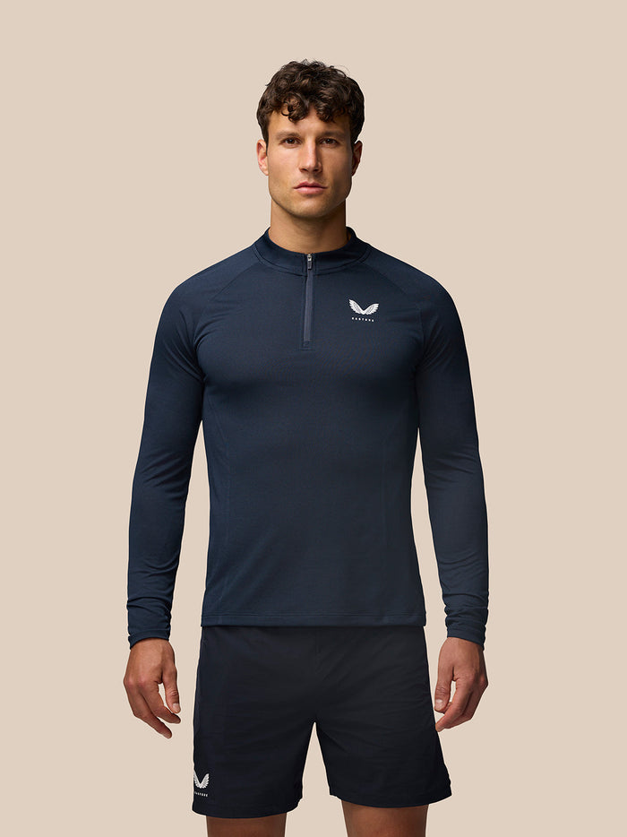 Man wearing midnight navy Apex Training Quarter Zip Top with stand collar and small Castore logo on chest