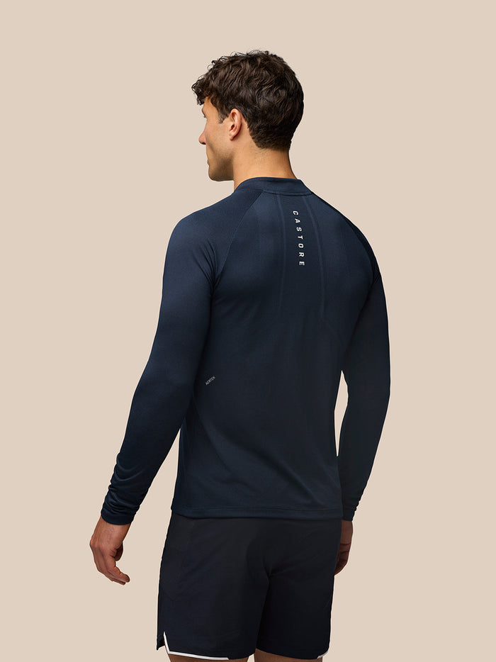 Back view of midnight navy Apex Long Sleeve Engineered Knit Quarter Zip Top with vertical Castore branding along the back