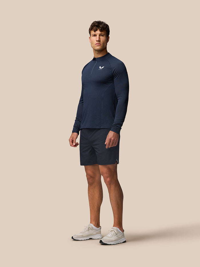 Male model wearing midnight navy Apex Training Quarter Zip Top with stand collar and left chest logo