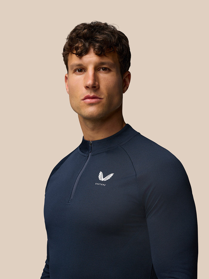 Front view of Midnight Navy Apex Training Quarter Zip Top on a model, displaying textured knit fabric and left chest Castore logo
