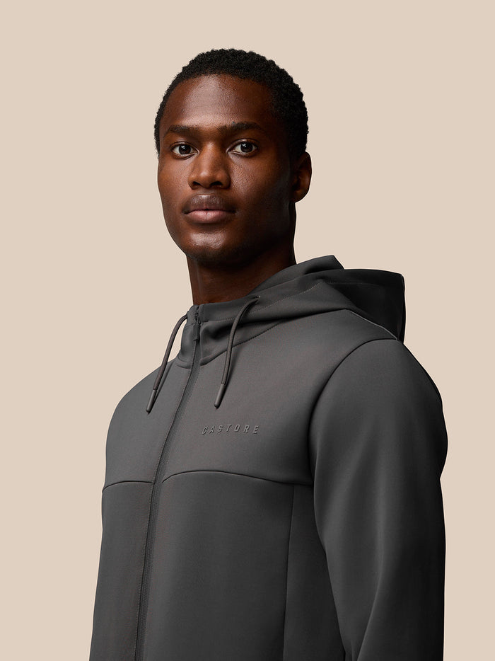 Side back view of a man wearing a charcoal Flex Lifestyle Full Zip hoodie with hood down