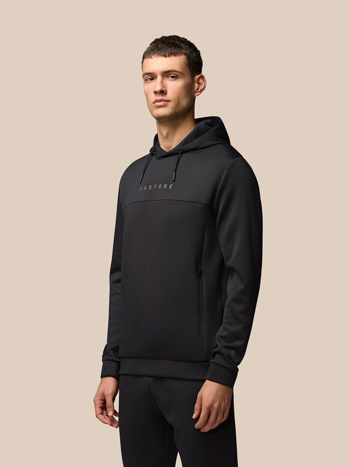 Male model wearing black Flex Hoodie with hood down, front view showing Castore logo on the chest and side zip pockets