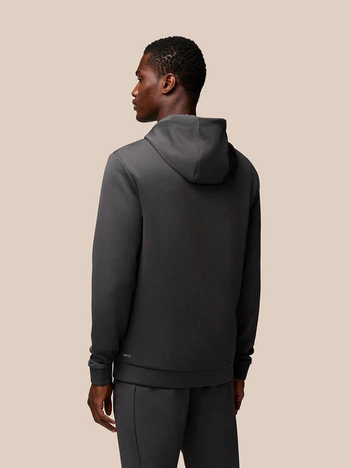 Back view of man in charcoal lifestyle hoodie with hood up and Protek branding at lower back