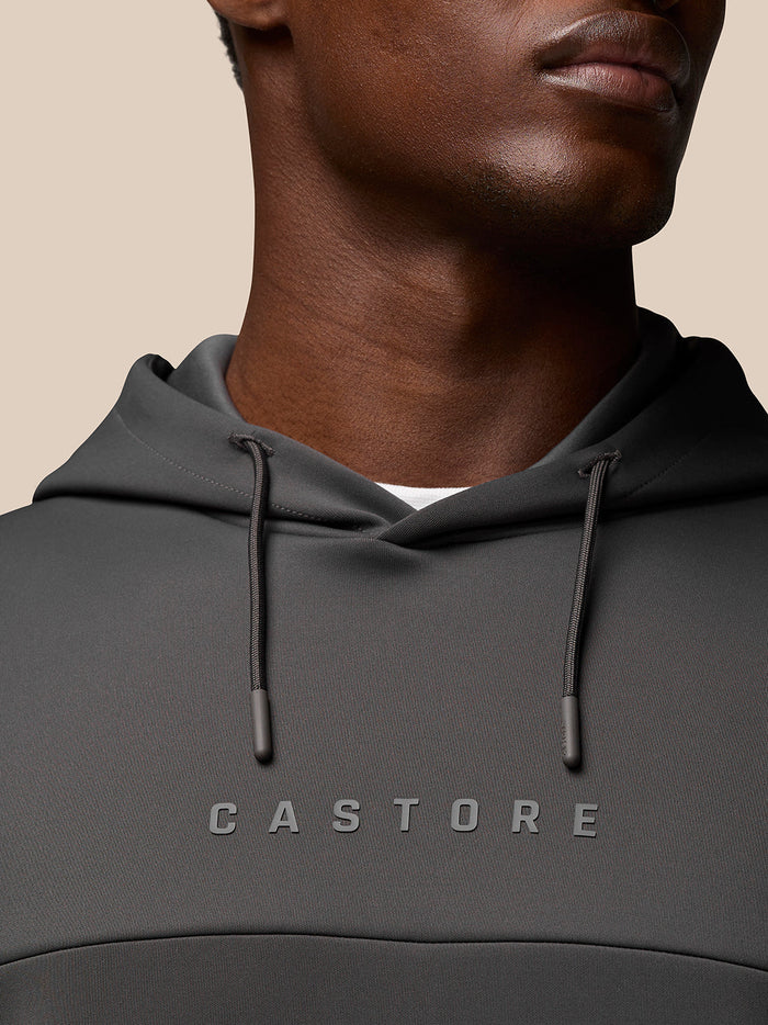 Close-up of model wearing Charcoal Flex Lifestyle Hoodie showing drawcord hood and Castore logo on chest.