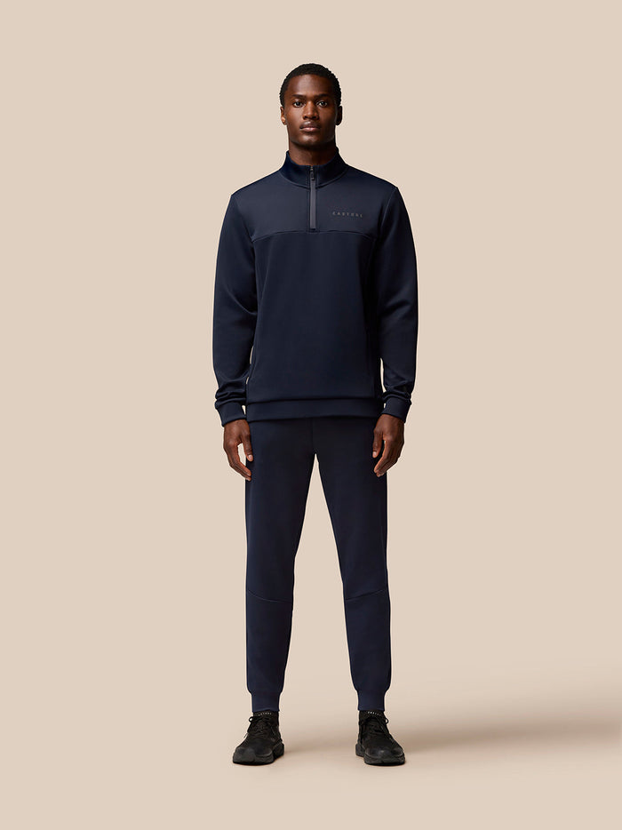 Full-body view of a model wearing navy Flex Lifestyle Quarter Zip set with matching joggers.