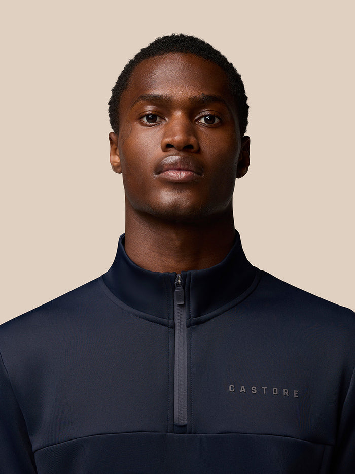 Back view of a man wearing the navy Flex Lifestyle Quarter Zip top with a high collar and smooth scuba fabric.