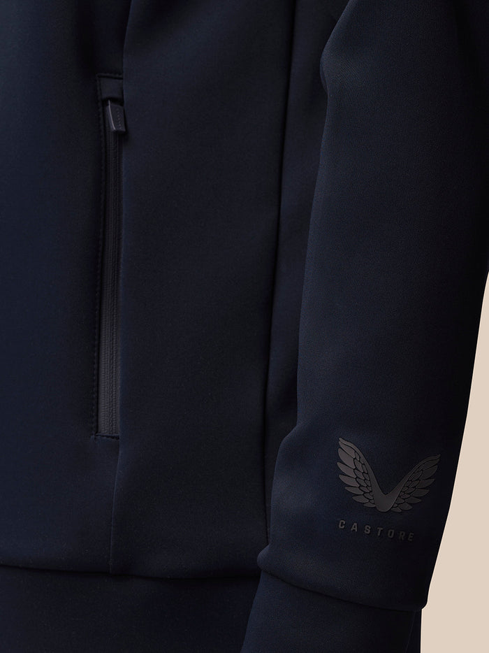 Close-up of navy Flex Lifestyle Quarter Zip showing a zip pocket and Castore logo on the sleeve.