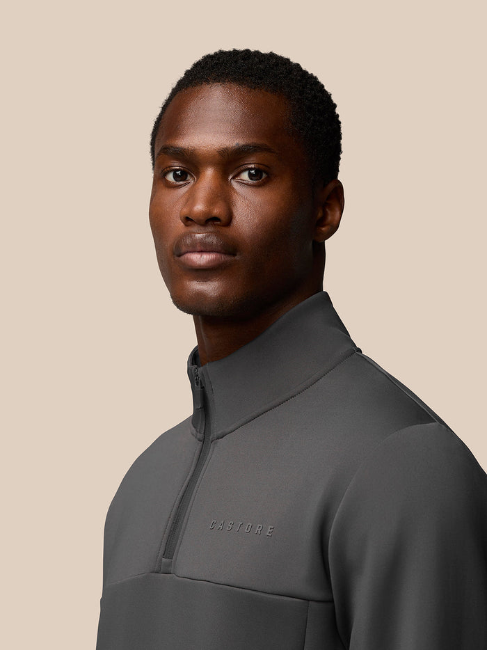 Three-quarter back view of male model in charcoal Flex 1/4 Zip Sweatshirt