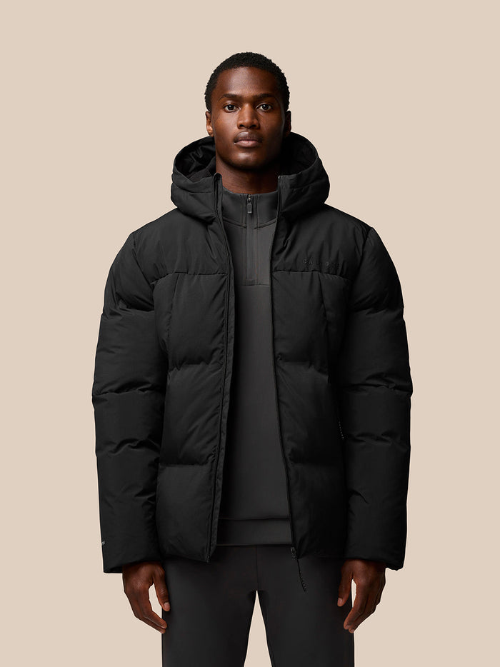 Male model in black hooded puffer jacket with zip front
