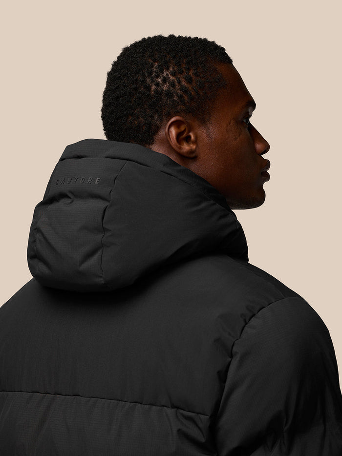 Back view of black puffer jacket hood with Castore branding along the hood seam