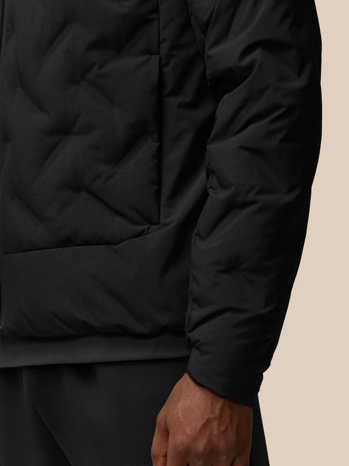 Close-up of black padded jacket sleeve with Protek branding on textured fabric.