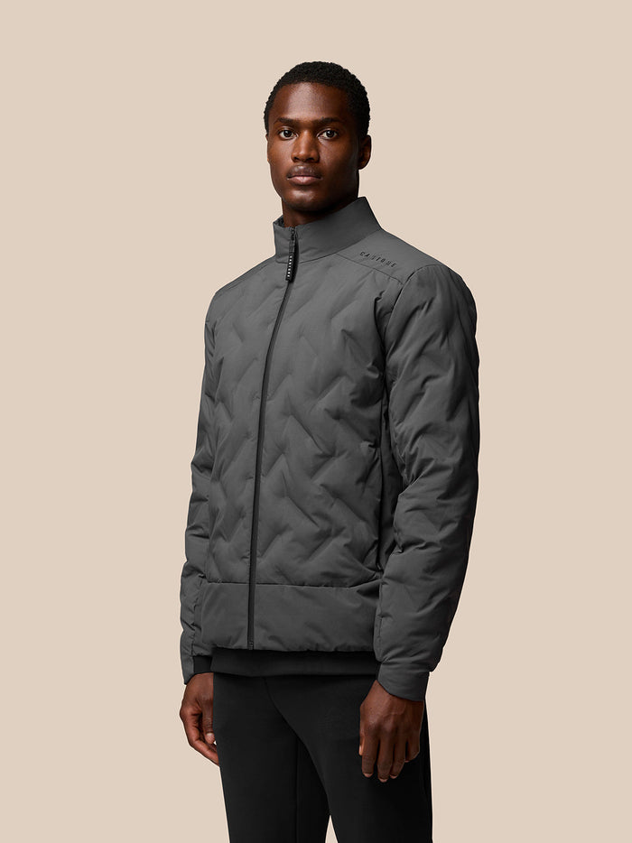 Male model wearing charcoal Quilts lightweight zip jacket with stand collar and quilted pattern