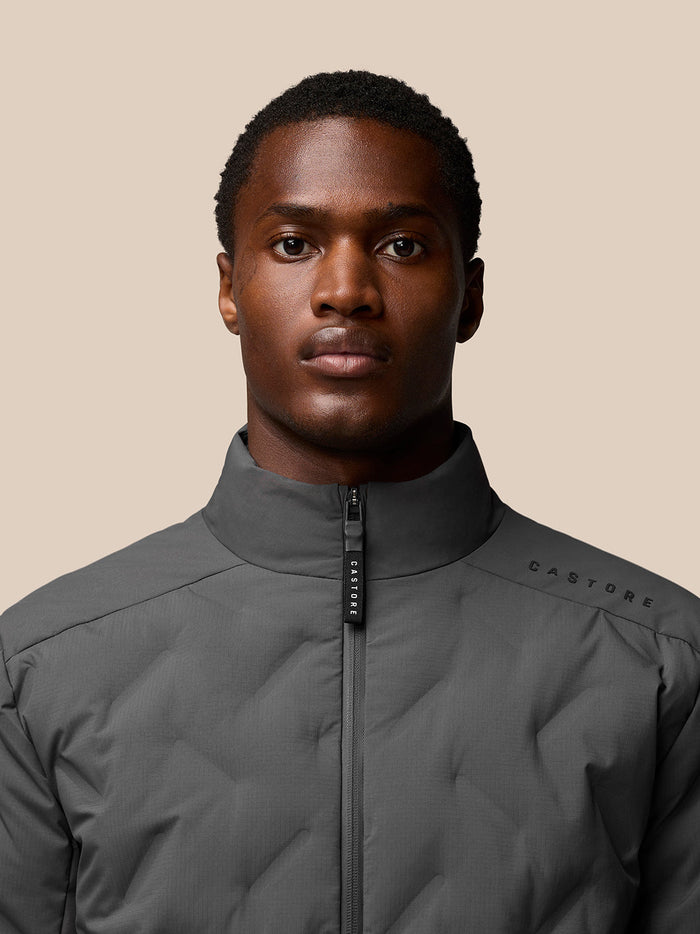 Male model wearing charcoal Quilts Lifestyle Jacket with stand collar and front zip