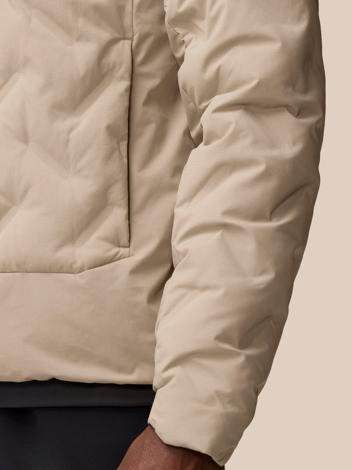 Close-up of mushroom padded jacket fabric with stitched panels and seam