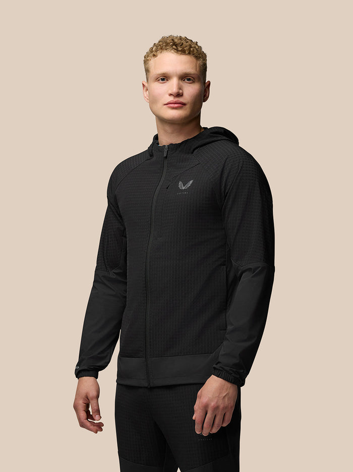 Front view of a male model wearing a black Flex Winterised Jacket with hood and full zip, Castore logo on chest.