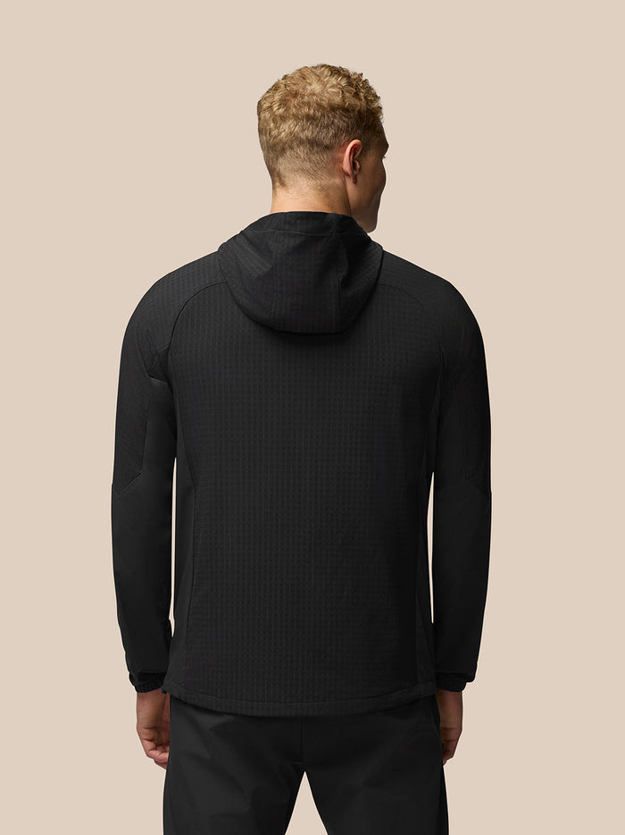 Back view of a male model in black Flex Winterised Jacket with hood and raglan sleeves.