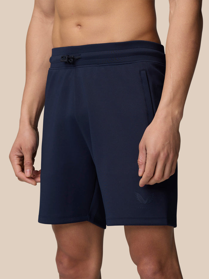 Model wearing midnight navy Flex Lifestyle Shorts with drawstring waist and Castore logo.