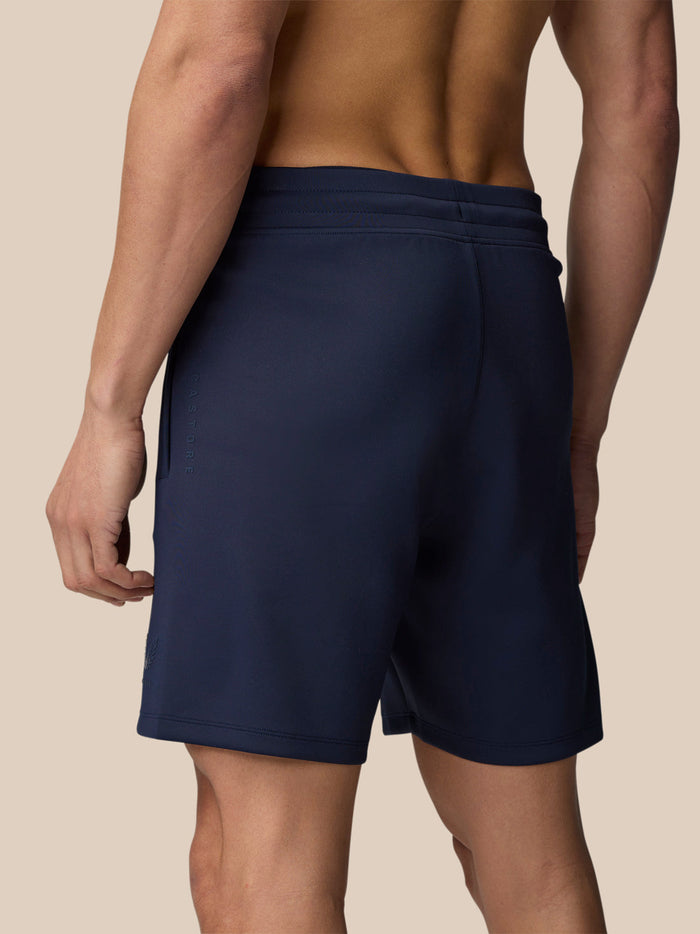 Back view of a male model wearing midnight navy Flex Lifestyle Shorts showing elastic waistband and smooth fit.