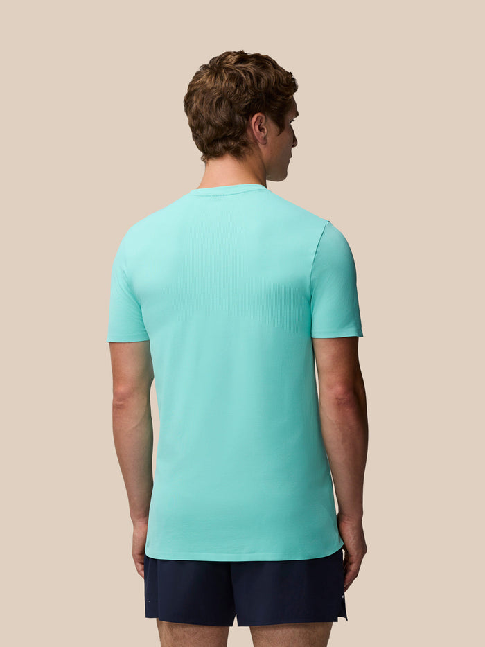 Back view of a man wearing light aqua Zone Training T Shirt with navy shorts and visible back ribbing