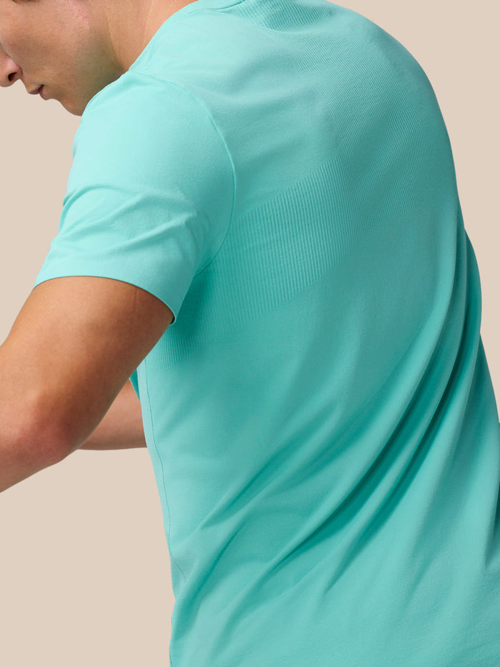 Side view of a model wearing Light Aqua Zone Training T-Shirt highlighting ribbed back panel