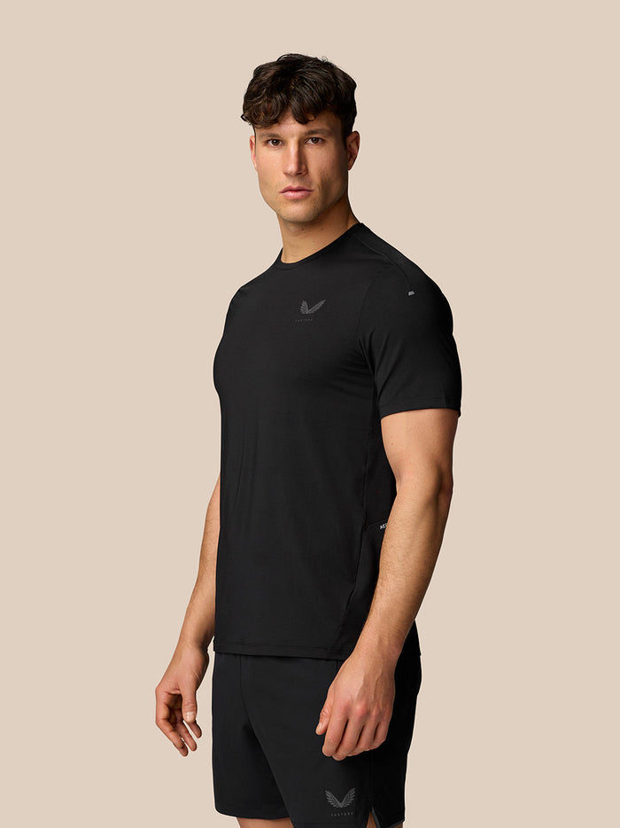 Angled side view of model wearing black Apex Training T-Shirt showing textured fabric and athletic fit